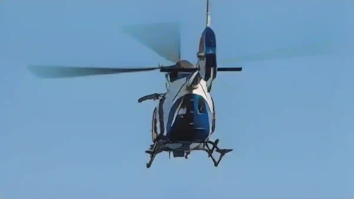 Полицейский вертолет пролетает над водоемом в рамках программы обучения.:Полицейский вертолет пролетает над водоемом в рамках программы обучения. Фото