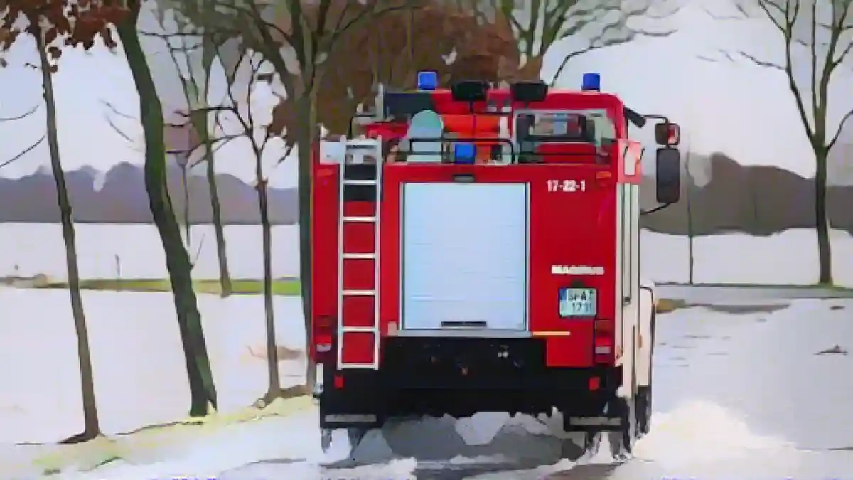 Пожарная машина едет по частично затопленной дороге недалеко от Аллера.:Пожарная машина едет по частично затопленной дороге недалеко от Аллера. Фото