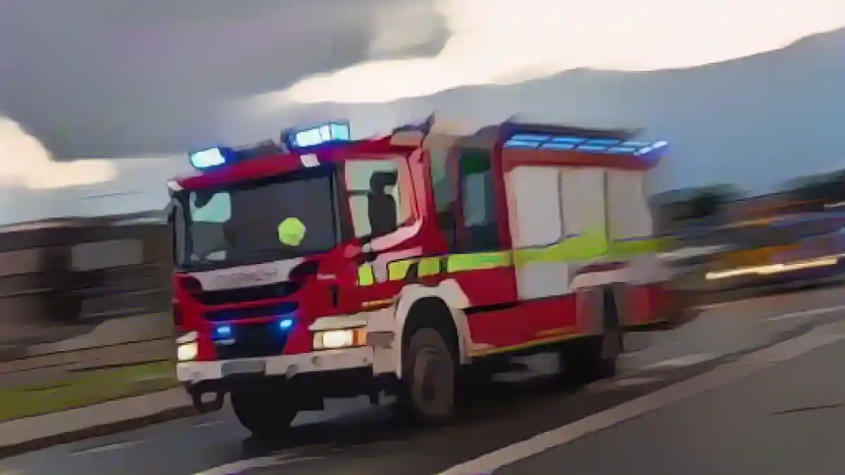 Пожарная машина пожарной бригады едет на операцию с мигающими синими огнями.:Пожарная машина пожарной бригады едет на операцию с мигающими синими огнями. Фото