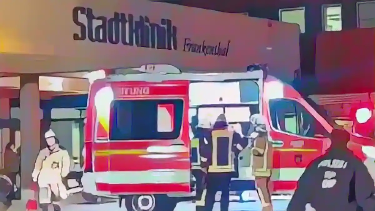 Пожарные стоят у машины скорой помощи перед зданием городской больницы Франкенталя.:Пожарные стоят у машины скорой помощи перед городской больницей Франкенталя. Фото