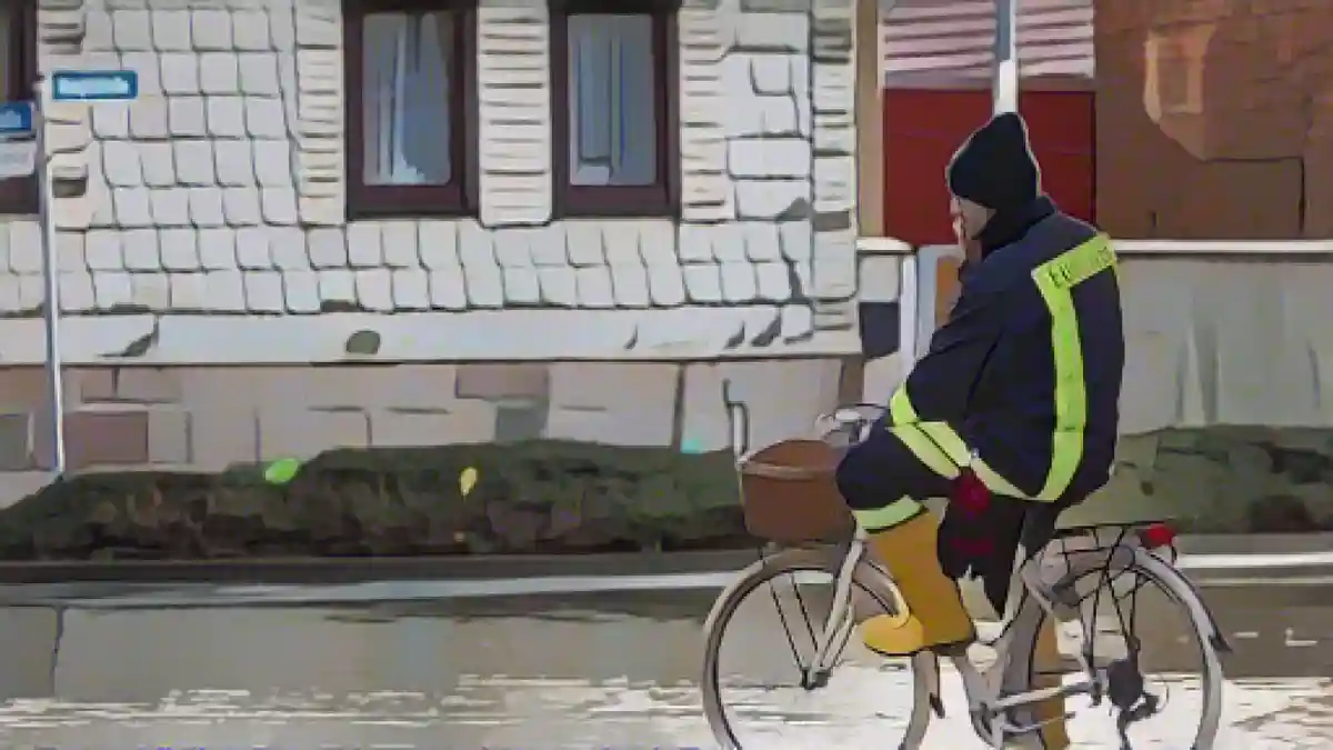Пожарный на велосипеде на затопленной улице в Виндехаузене.:Пожарный на велосипеде на затопленной улице в Виндехаузене. Фото