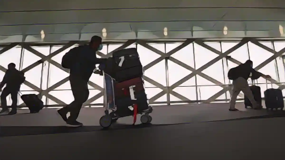 Путешественники идут со своим багажом в международном аэропорту Сан-Франциско 01 июля 2022 года в Сан-Франциско, Калифорния:Путешественники идут со своим багажом в международном аэропорту Сан-Франциско 01 июля 2022 года в Сан-Франциско, штат Калифорния.