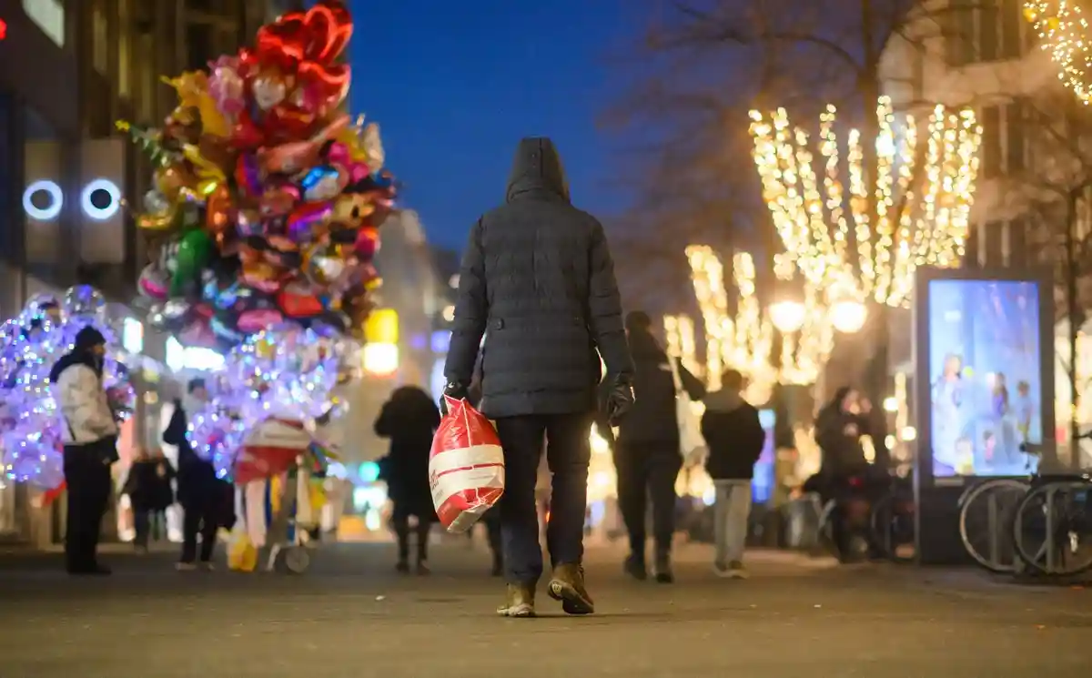 Ритейлеры беспокоятся о рождественском бизнесе:Прохожий идет по центру города с сумкой для покупок.