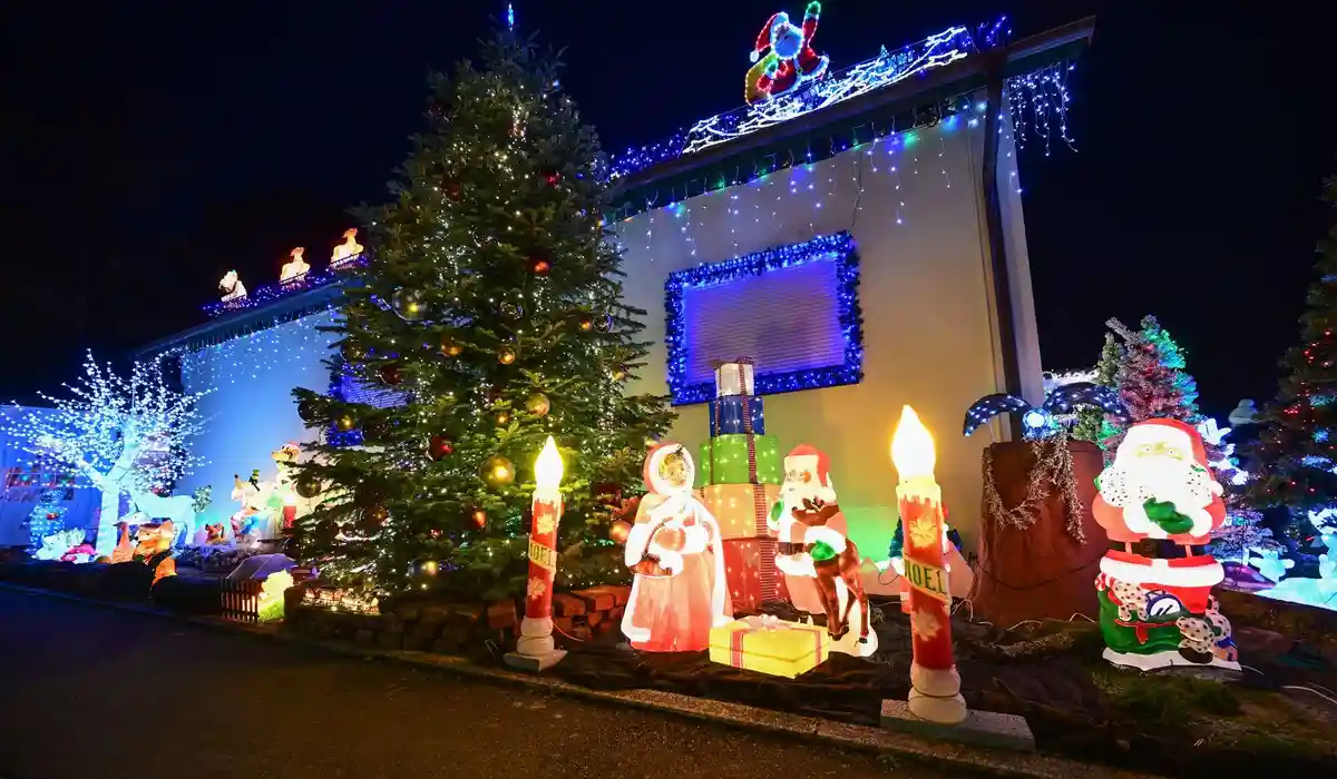 Рождественские дома снова сияют:Посетители рассматривают иллюминированные фигуры и огни в частном рождественском доме.