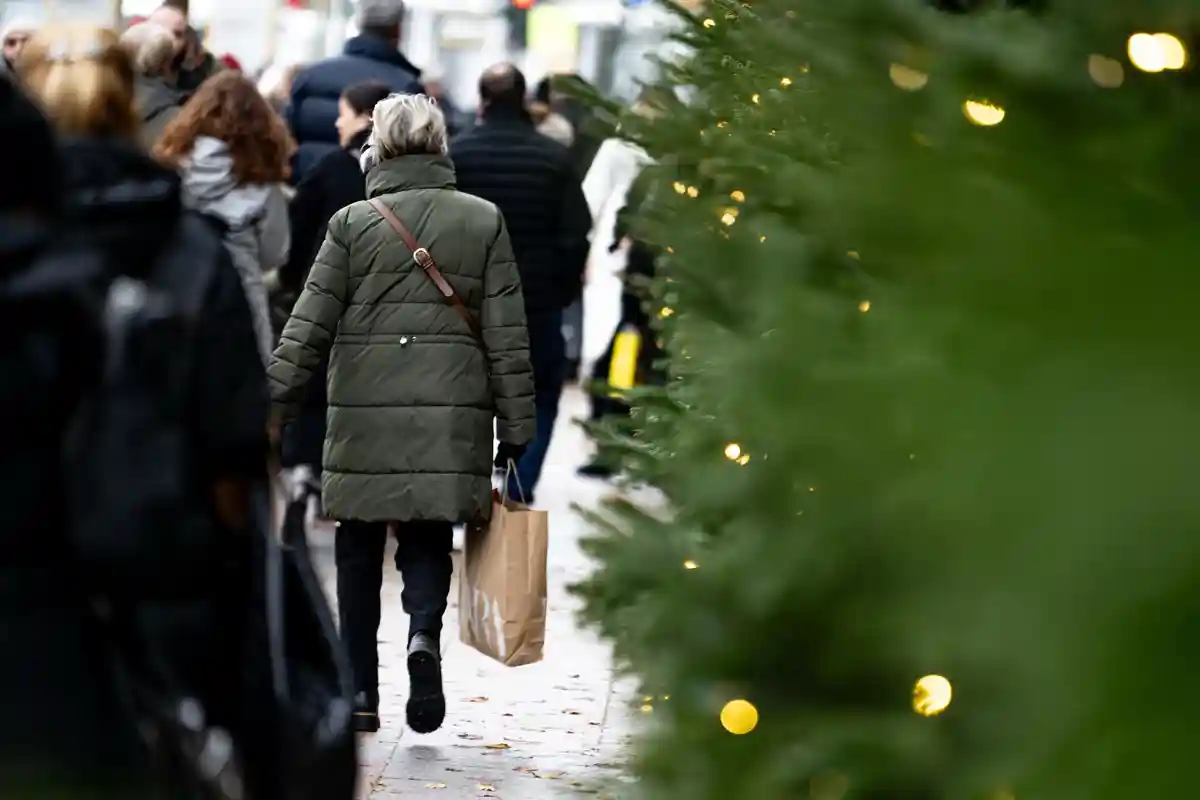 Рождественские покупки:В воскресенье, когда магазины открыты, люди ходят по Берлин-Митте с пакетами покупок.