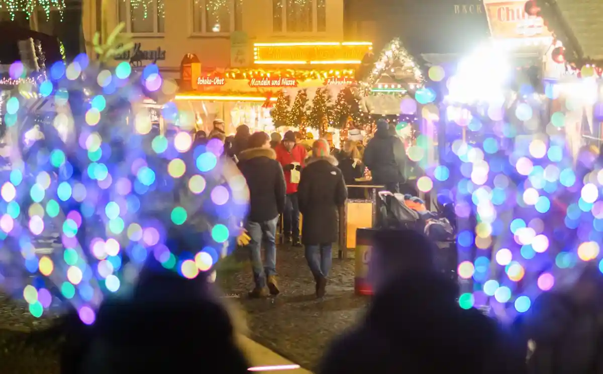 Рождественский рынок в Хильдесхайме:Посетители гуляют по рождественскому рынку в Хильдесхайме.