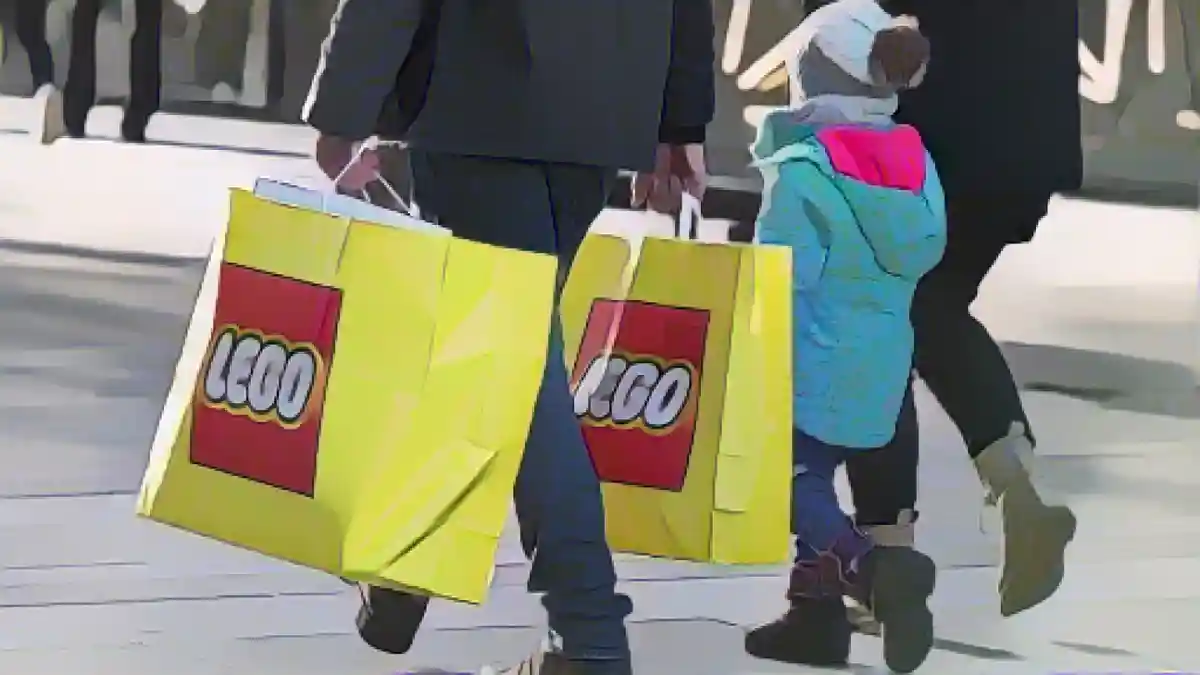 Розничная торговля: семья проходит по улице с полными сумками Lego:Если вы не успели купить все подарки до Рождества, забастовки в секторе розничной торговли могут осложнить вам жизнь