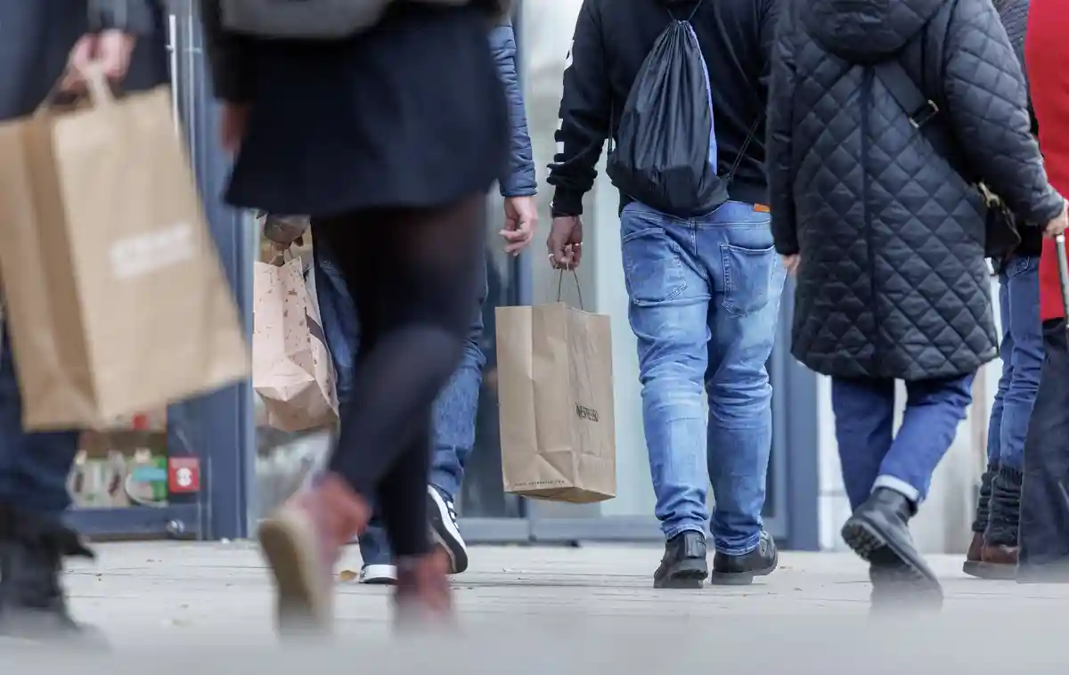 Розничная торговля:Люди идут по улице с сумками для покупок.