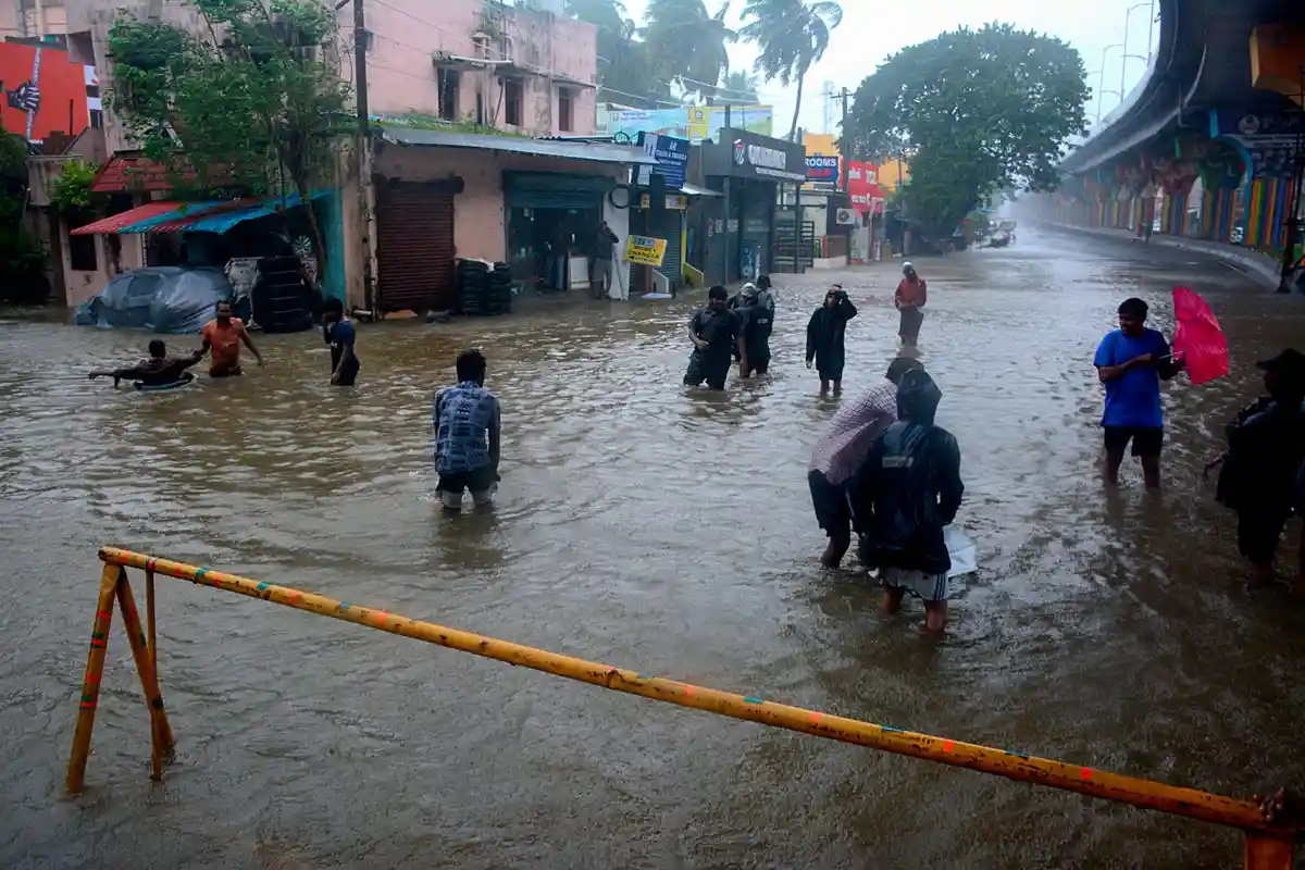 Шторм Михаунг в Южной Индии:Люди пробираются по затопленной улице после сильных дождей на побережье Бенгальского залива.