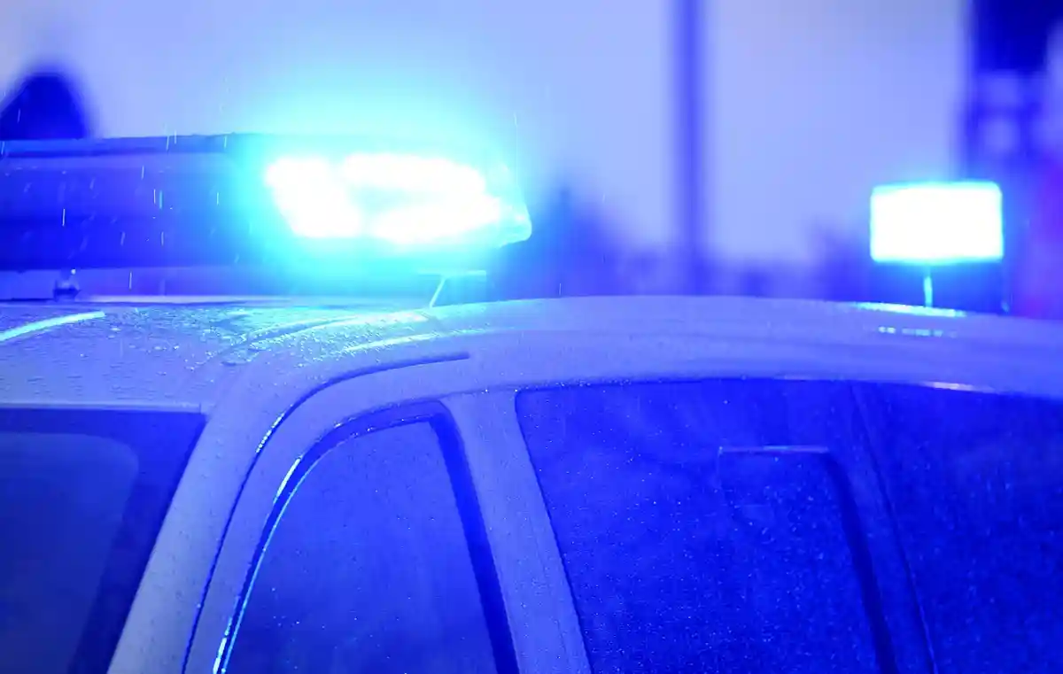 Синие огни светят на крыше патрульной машины:На крыше полицейской патрульной машины светятся синие огни.