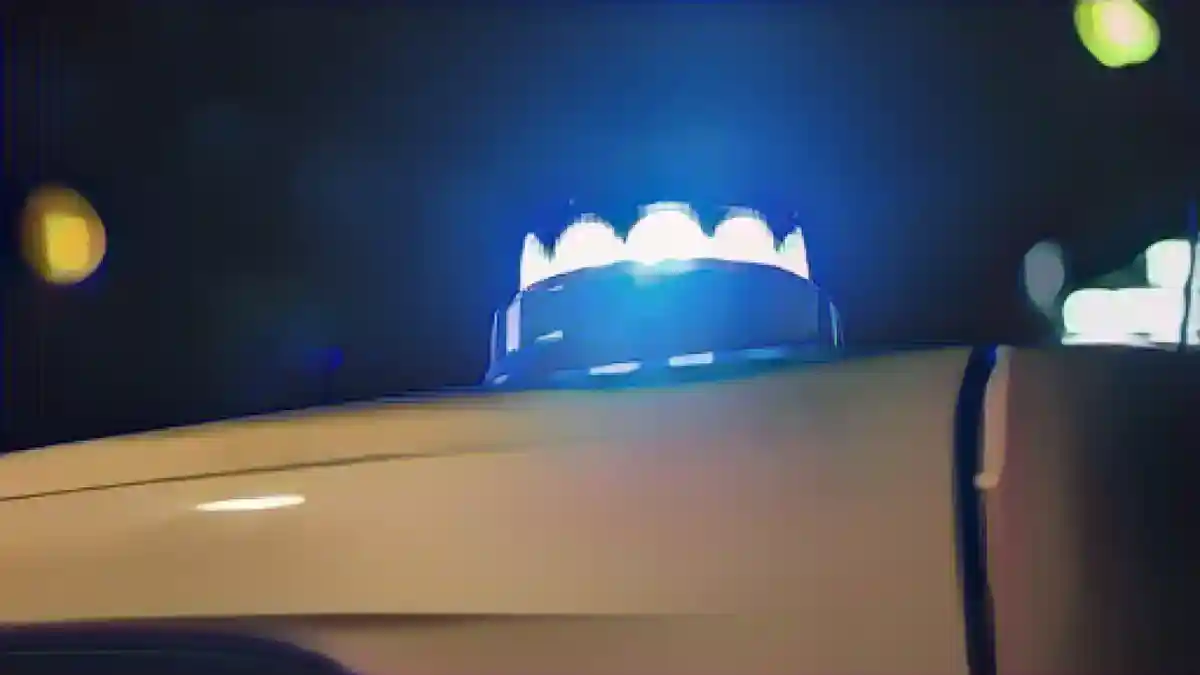 Синий фонарь светит на крышу полицейского автомобиля.:Синий фонарь светит на крышу полицейского автомобиля. Фото