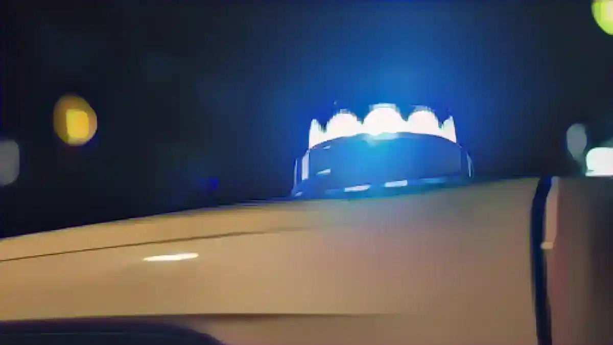 Синий фонарь светит на крышу полицейского автомобиля.:Синий фонарь светит на крышу полицейского автомобиля. Фото
