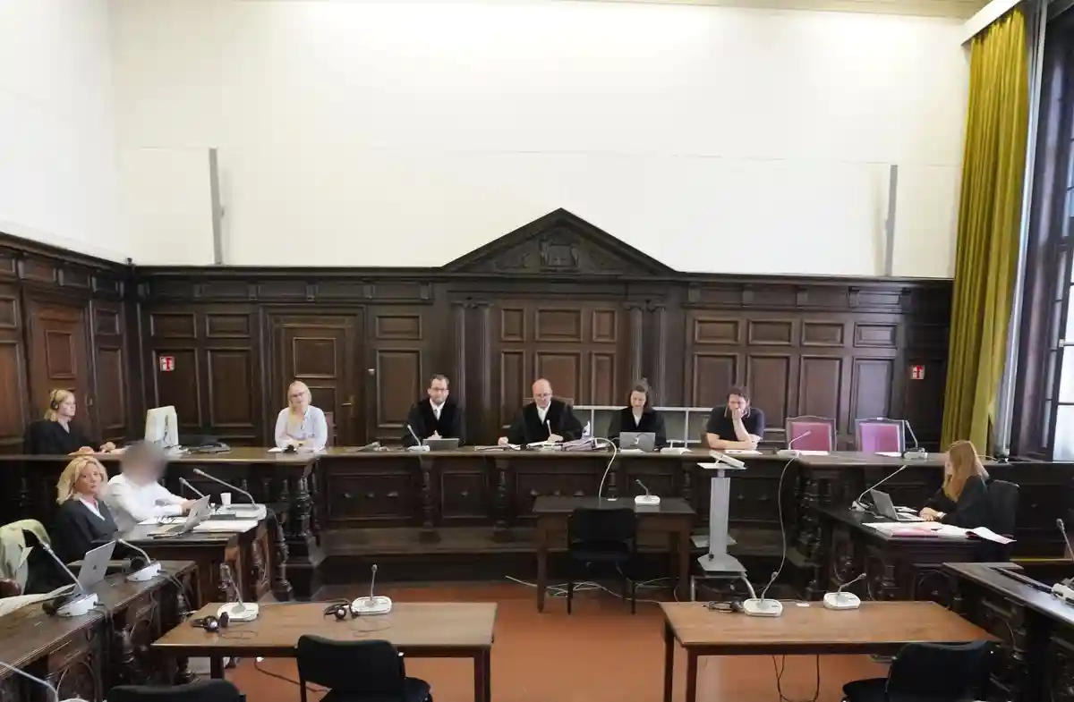 Суд над 25-летним мужчиной, обвиняемым в убийстве:Обвиняемый (3-й слева) сидит в начале первого судебного заседания в здании уголовного правосудия.