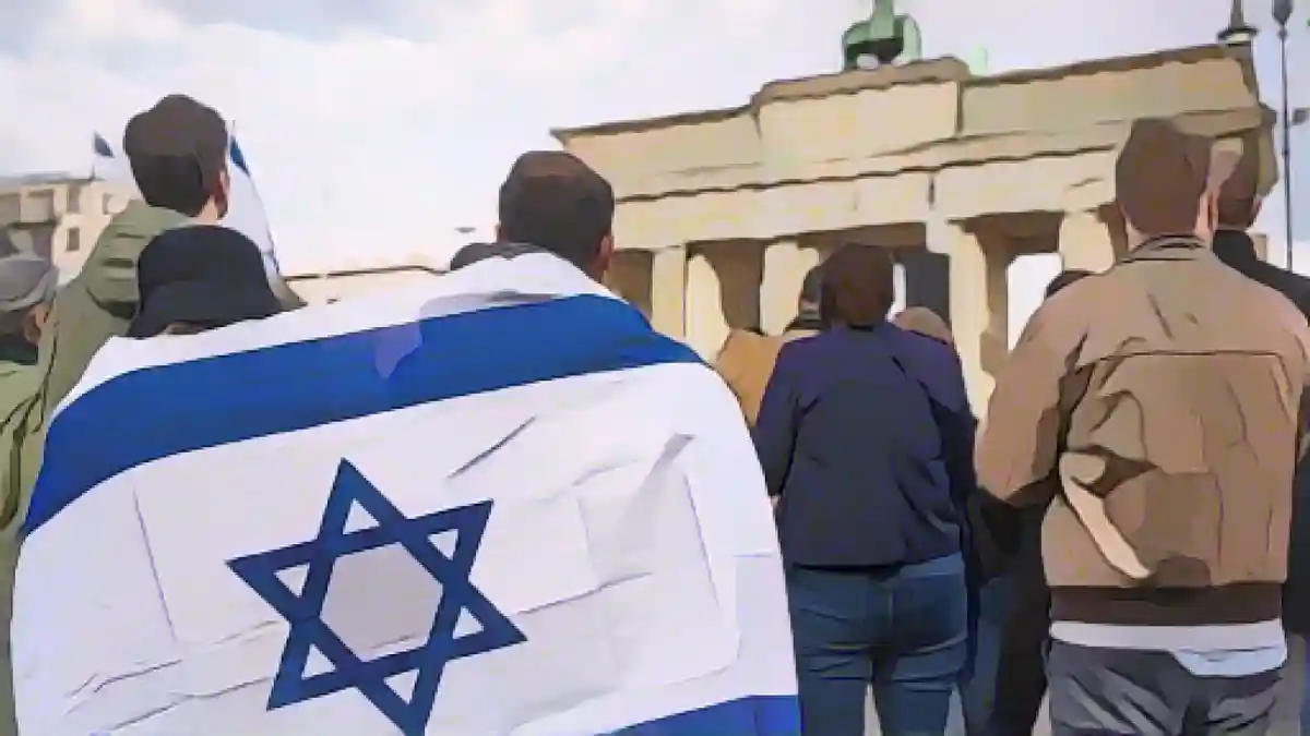 Участники митинга "Выступим против террора, ненависти и антисемитизма - в знак солидарности и сострадания с Израилем" стоят у:Участники акции "Выступи против террора, ненависти и антисемитизма - в знак солидарности и сострадания с Израилем" стоят, завернувшись в израильский флаг, перед Бранденбургскими воротами в Берлине. Фото