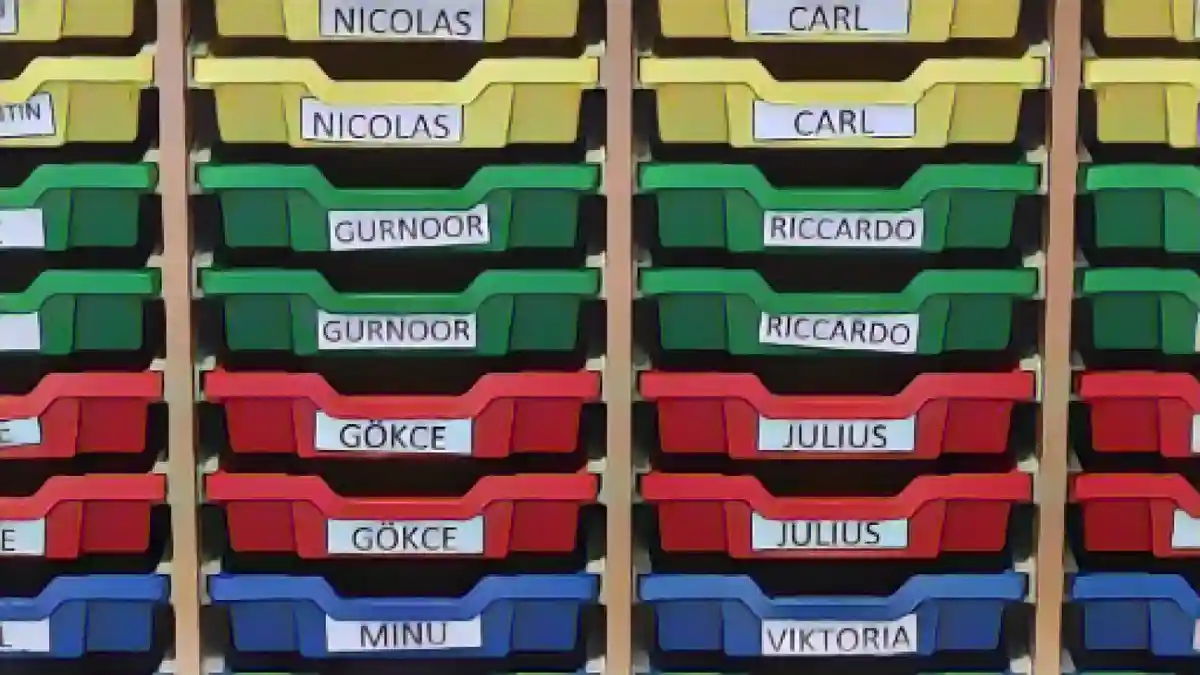 В одном из классов ящики для хранения вещей помечены именами учеников.:В одном из классов отсеки для хранения вещей помечены именами учеников. Фото