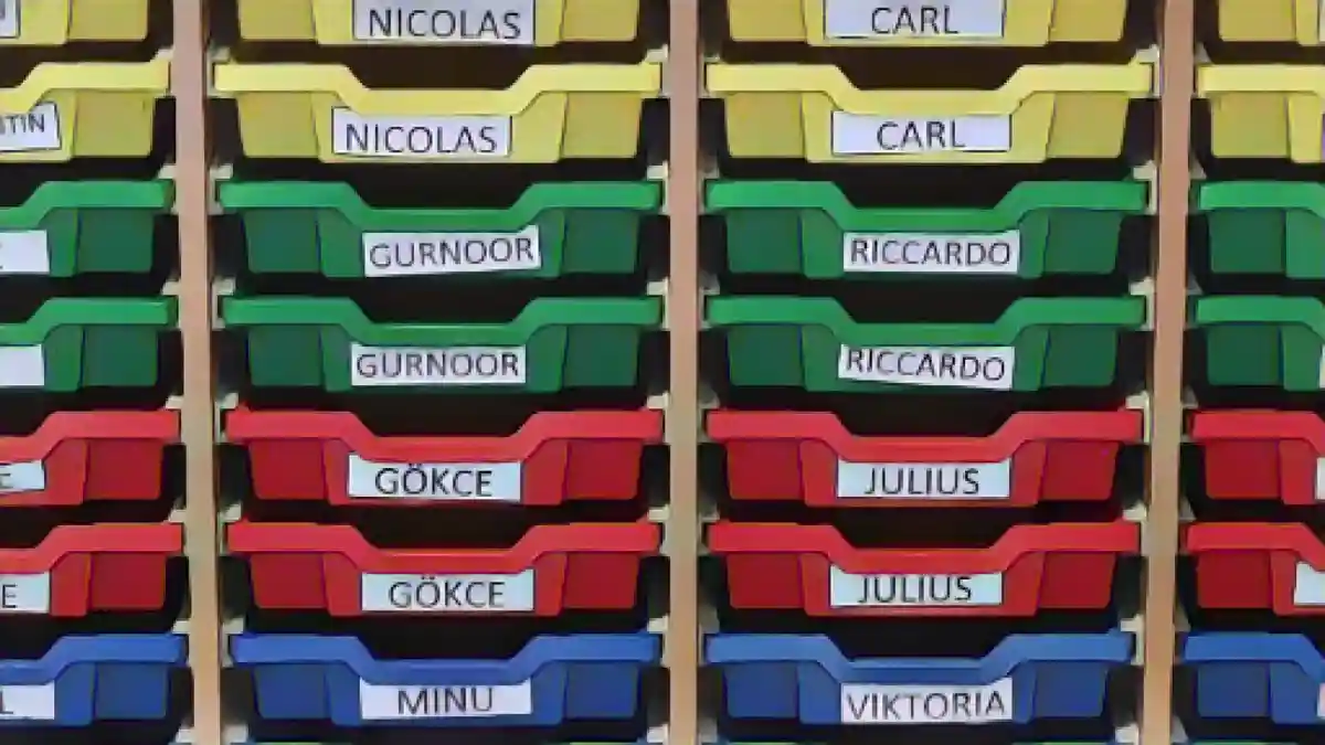 В одном из классов ящики для хранения вещей помечены именами учеников.:В одном из классов отсеки для хранения вещей помечены именами учеников. Фото