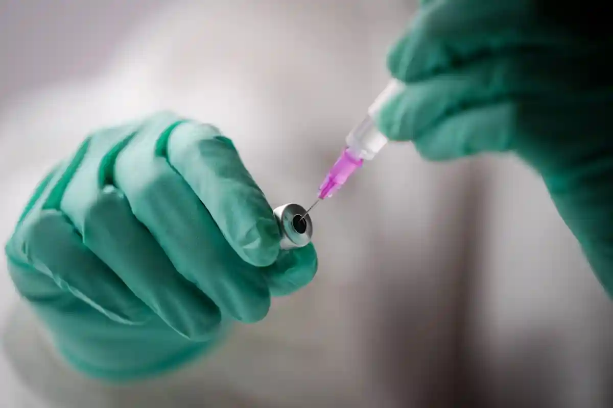Вакцинация против короны:Сотрудник наполняет шприц дозой коревой вакцины.