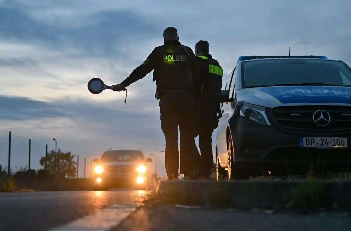 Вход:Сотрудники Федеральной полиции останавливают автомобиль, въезжающий в страну, на границе рано утром.