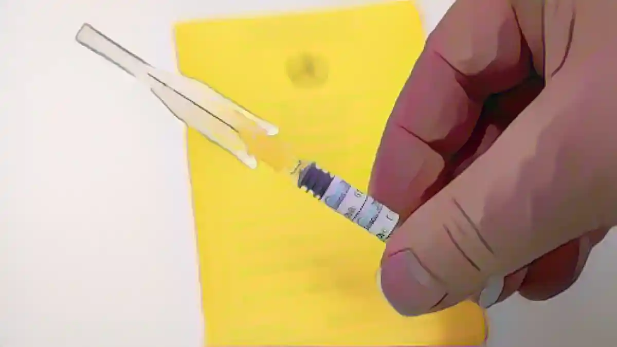 Врач держит шприц с вакциной против гриппа Influvac Tetra над картой прививок.:Врач держит шприц с вакциной против гриппа Influvac Tetra над картой прививок. Фото