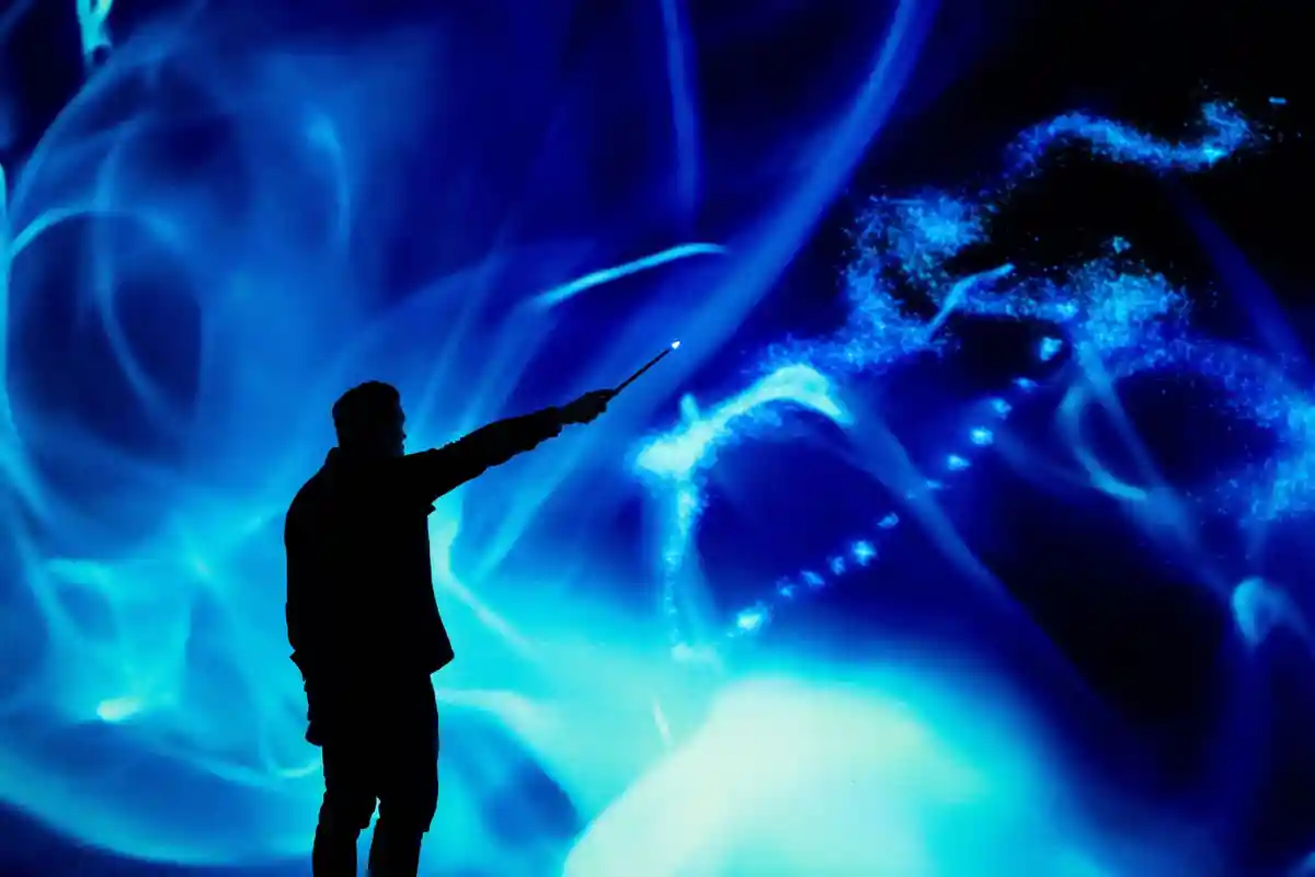 Выставка "Гарри Поттер: видения волшебства":Посетитель стоит перед цифровым экраном на выставке "Гарри Поттер: видения магии" в Оддисеуме.