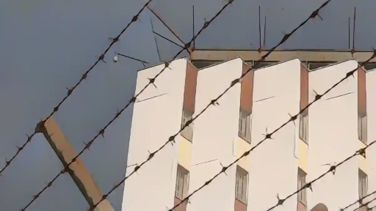 Забор из колючей проволоки окружает территорию тюрьмы.:Забор из колючей проволоки окружает территорию тюрьмы. Фото