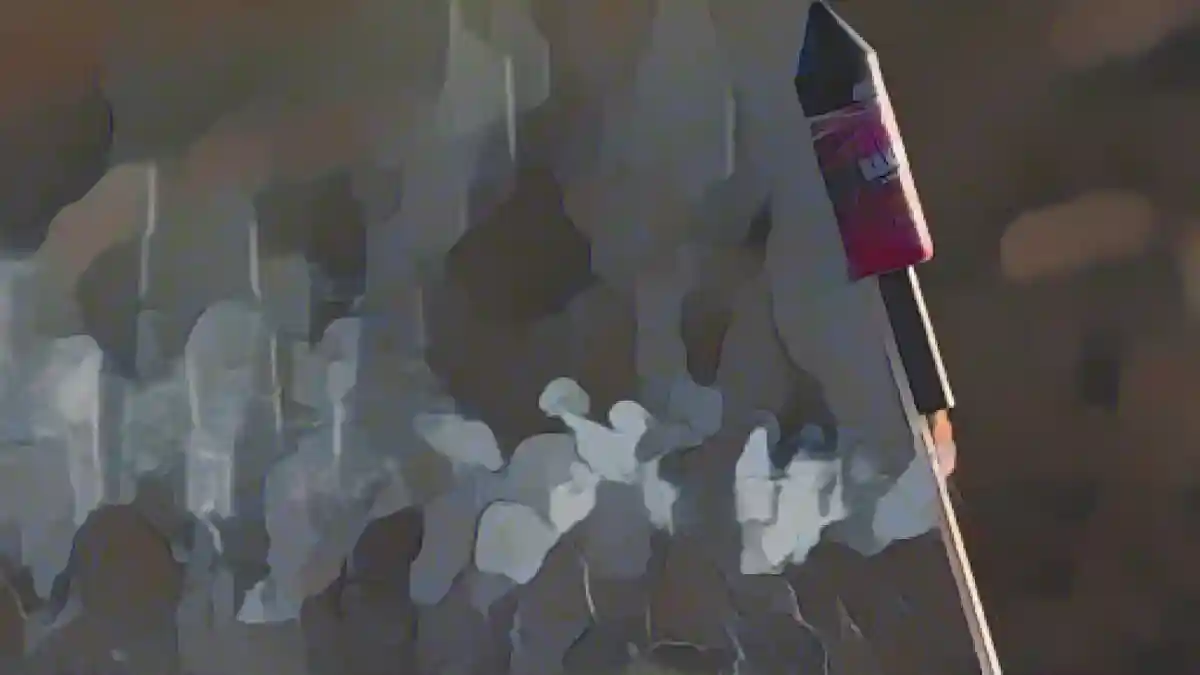 Зажженная новогодняя ракета застряла в земле.:Зажженная новогодняя ракета застряла в земле. Фото