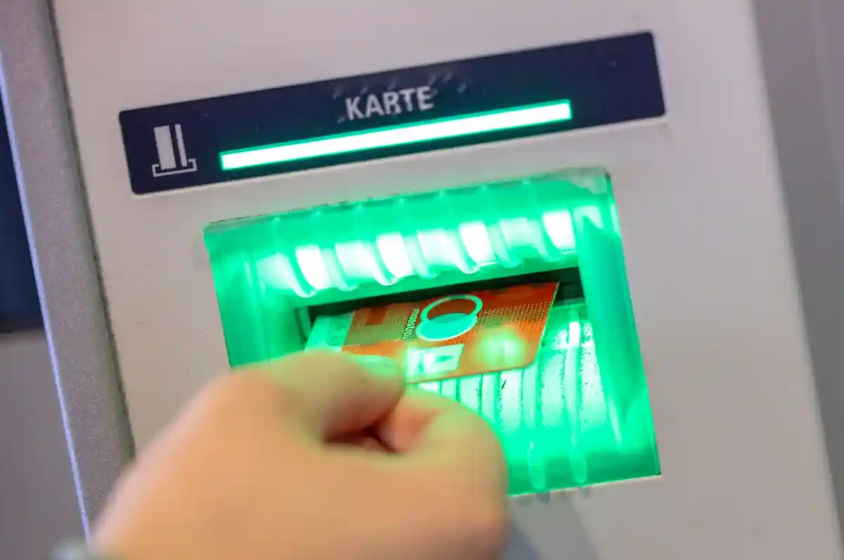Жирокарты без функции Maestro:Клиент банка вставляет свою дебетовую карту в банкомат.