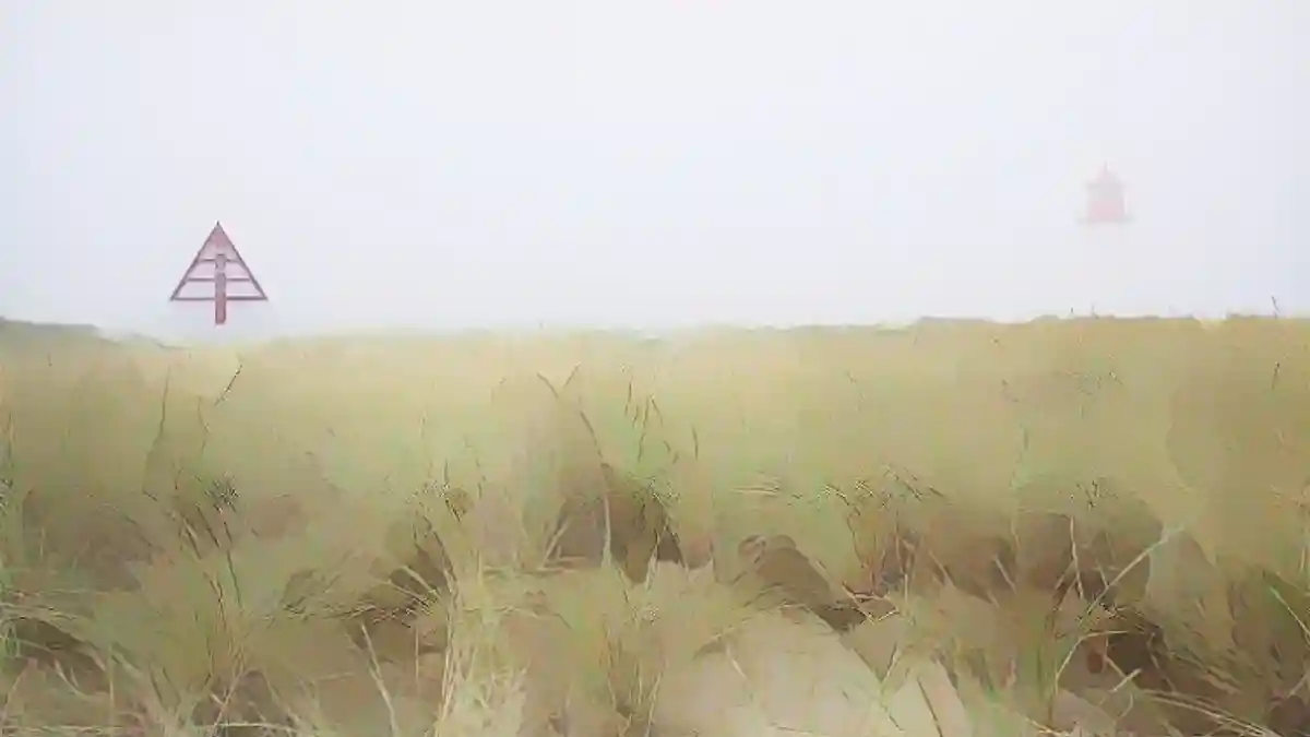 Зюльт, 29.12.2021: Маяк Лист-Вест и навигационный знак (метка) в тумане на фоне дюнного ландшафта в Элленбоге:Зюльт, 29.12.2021: Маяк Лист-Запад и навигационный знак (метка) в тумане на фоне дюнного ландшафта в Элленбогене