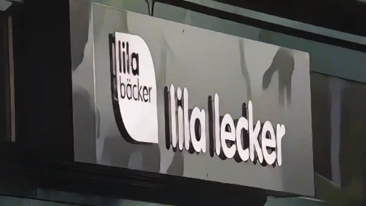 Логотип компании Lila Bäcker с надписью "lila lecker" на ветке.:Логотип компании Lila Bäcker с надписью "Lila Lecker" на ветке. Фото