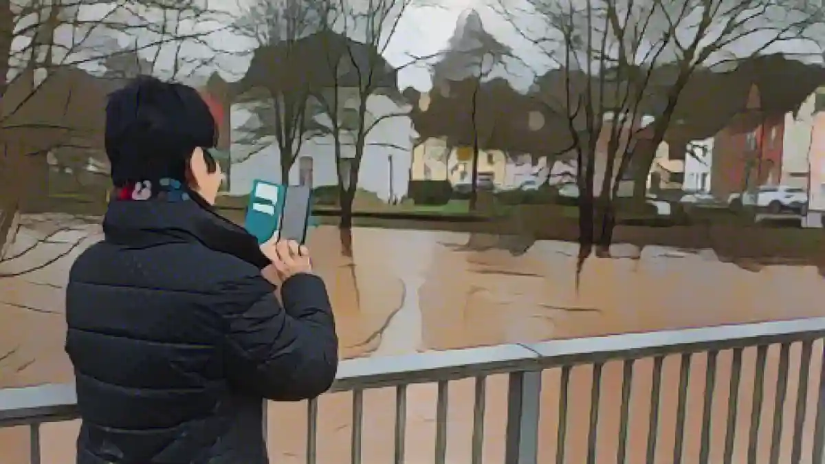 Местный житель с помощью смартфона фотографирует наводнение в Блис с моста.:Местный житель фотографирует наводнение в Блис с моста с помощью смартфона. Фото