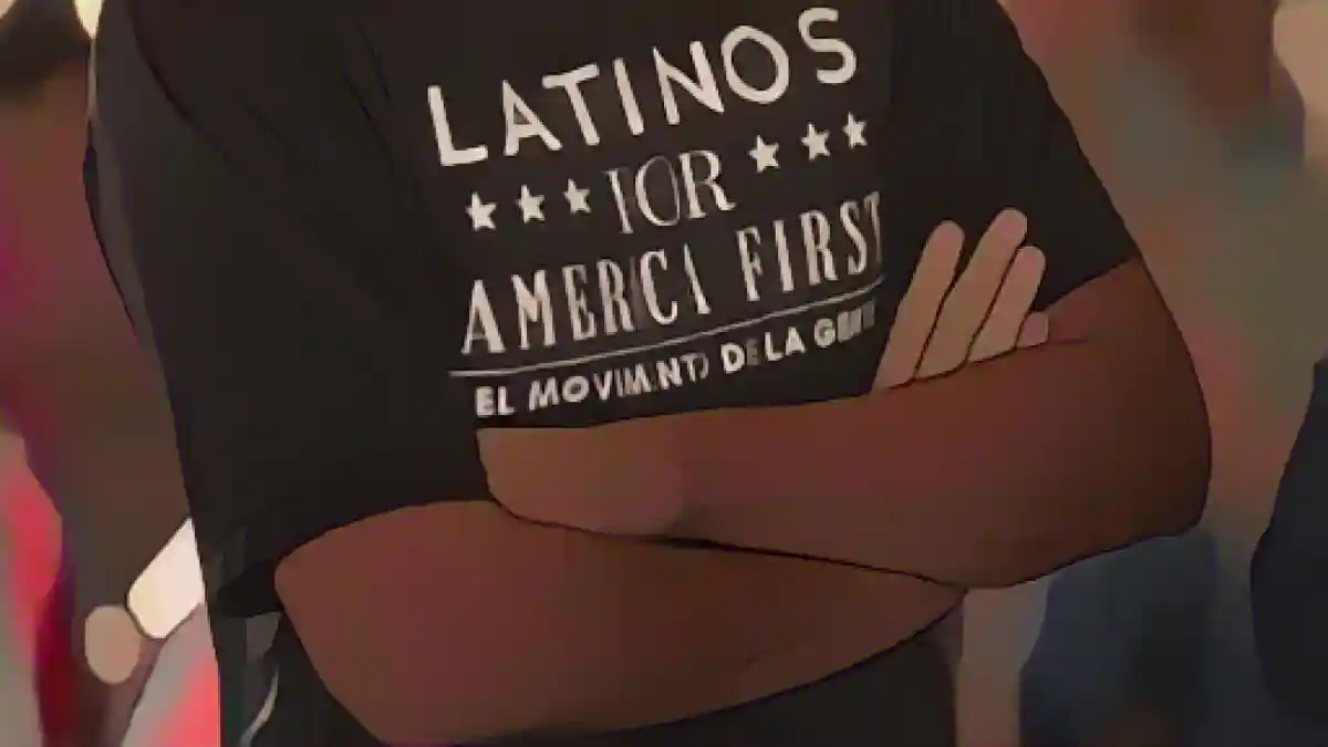 Перед промежуточными выборами: Сторонник Трампа в Техасе надевает футболку с надписью "Латиносы за Америку прежде всего:Сторонник Трампа в Техасе надевает футболку с лозунгом "Латиносы за Америку прежде всего".