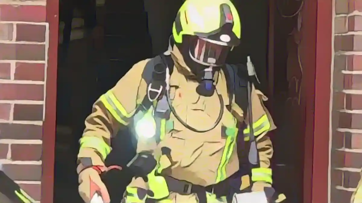 Пожарный выходит из жилого дома во время тушения пожара.:Пожарный выходит из жилого дома во время тушения пожара. Фото