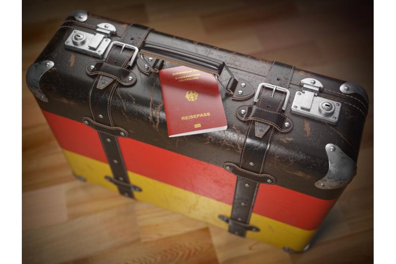 Passport of Germany and suitcase with flag of Germany