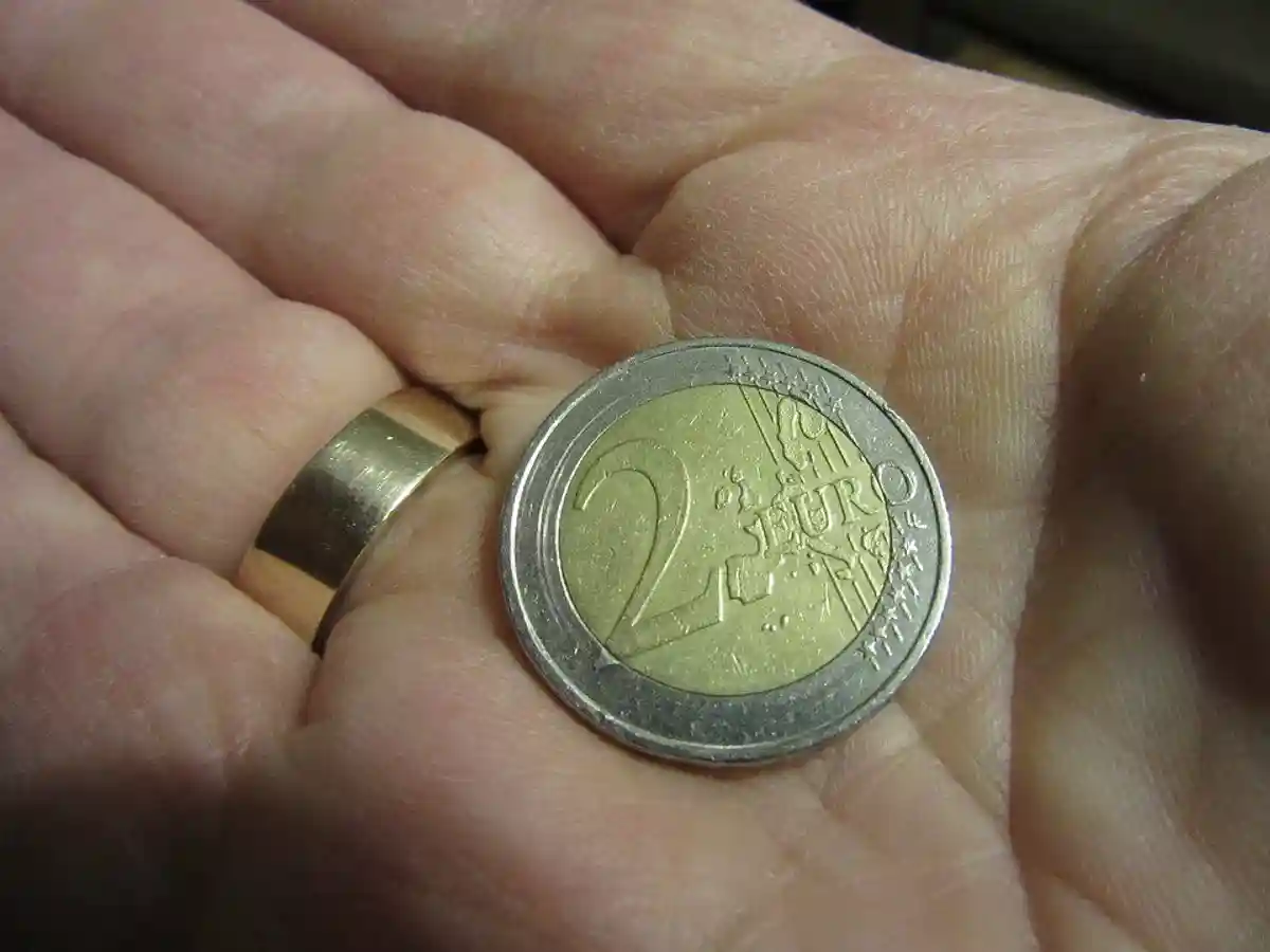 монета номиналом 2 евро на ладони фото