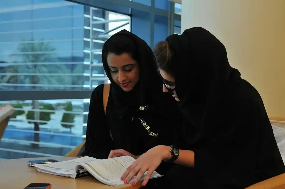две арабские девушки изучают содержимое книги фото